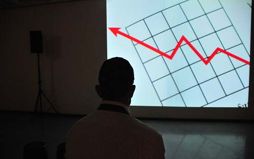 indoors man wearing white top looking at projector graph screen interior design
