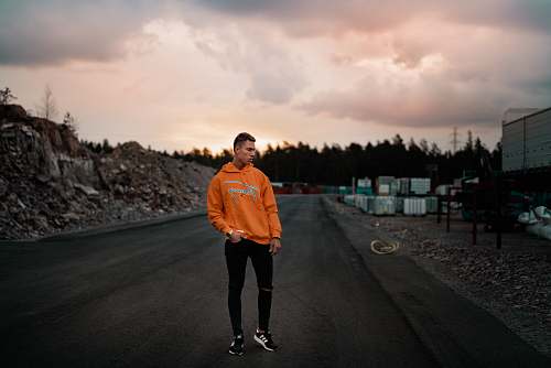 human men's orange pullover hoodie and black pants people