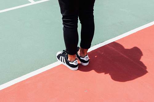 people person wearing black adidas sneakers human