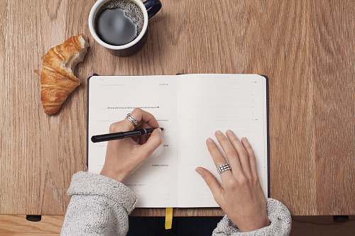 writing person writing on a book coffee