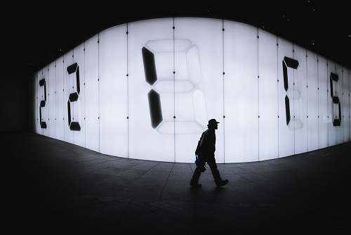 human photo of man walking near LED signage people