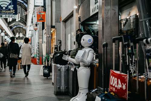people robot standing near luggage bags robot