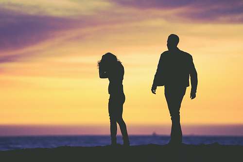 people silhouette of man and woman under yellow sky silhouette