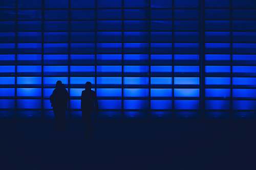 human silhouette photo of two person standing near wall silhouette
