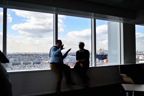 human two men sitting beside window having conversation housing