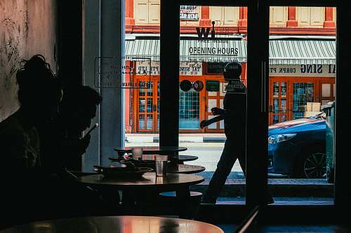 people two person inside building near glass door during daytime silhouette