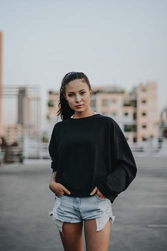 human woman inserting her both hands in blue denim hot shorts pockets outdoors people