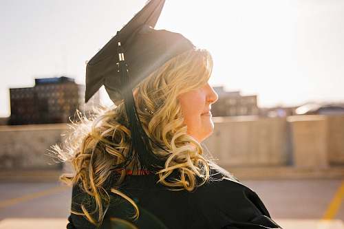 people woman wearing academic regalia during daytime woman