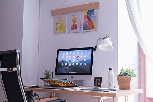 desk white iMac on brown wooden desk pottery