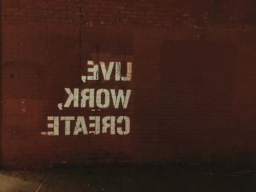 inspiration red brick wall with live, work, create. quote words