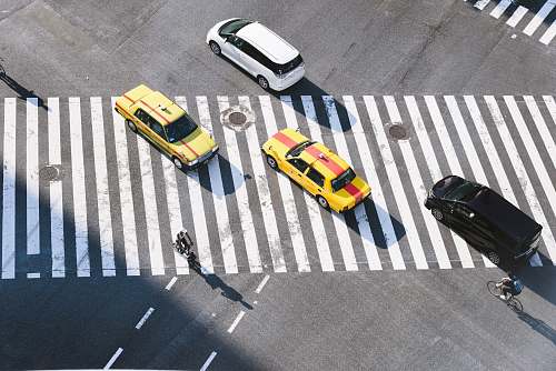 asphalt aerial photo of four vehicles on road at daytime tarmac