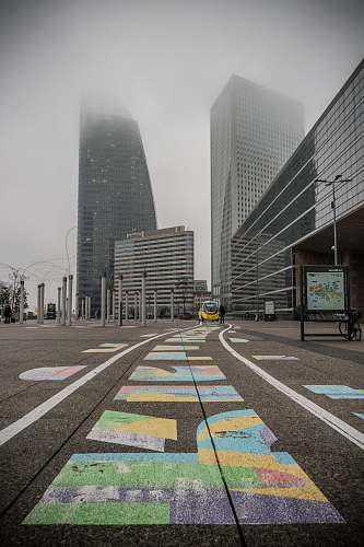 asphalt selective color photography of yellow car near building during daytime tarmac