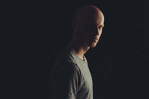 clothing man wearing gray crew-neck shirt using Apple AirPods standing and facing his left side apparel