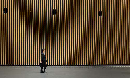japan man in black suit jacket walking on road minimnal