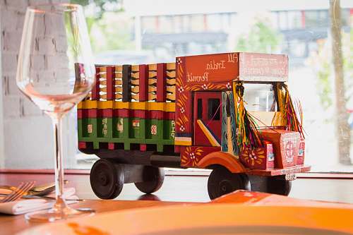 truck multicolored truck toy near wine glass vehicle