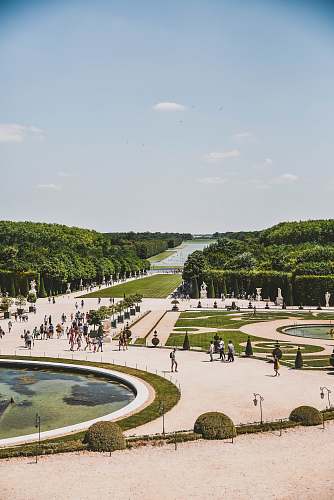 town people standing beside fountain during daytime building