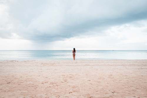 nature person standing on seashore during daytime outdoors