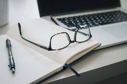 glasses black framed eyeglasses and black pen grey