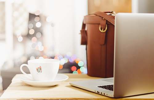coffee gray laptop beside teacup and bg cup