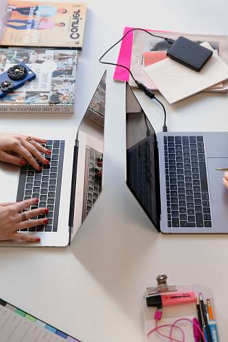 paper person typing on silver laptop computer office