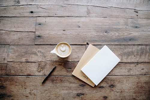 coffee black twist pen near white teacup desk