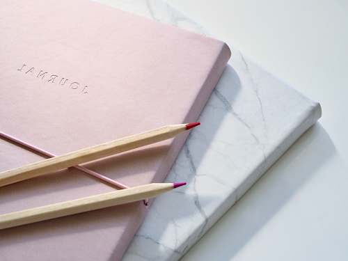 journal red and purple coloring pencils on pink journal flatlay