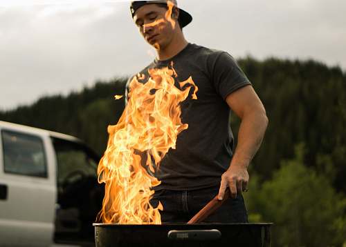 flame man grilling near white vehicle fire