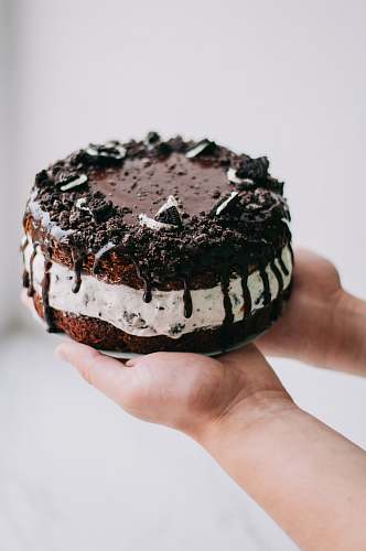 food naked drapery chocolate cookies and cream cake on person's hands cake