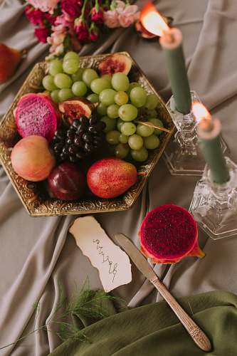 fruit assorted fruits in bowl near lighted green candles plant