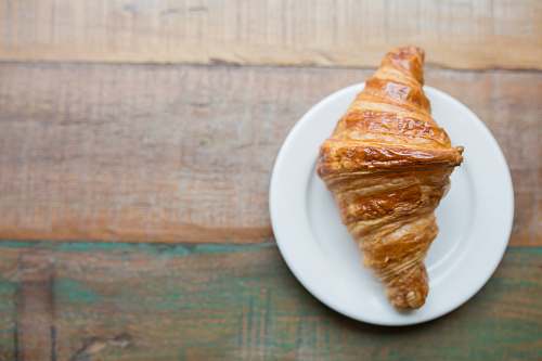 bread baked pastry on white ceramic saucer croissant