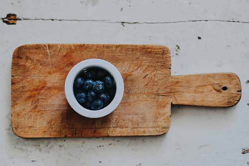 fruit blueberries on white saucer on chopping board blueberry