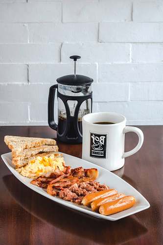 meal bread and bacon platter beside French press breakfast