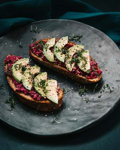 plant bread with sliced avocado and garnish with herbs vegetable
