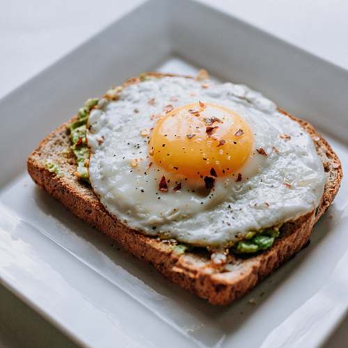 bread bread with sunny side-up egg served on white ceramic plate breakfast
