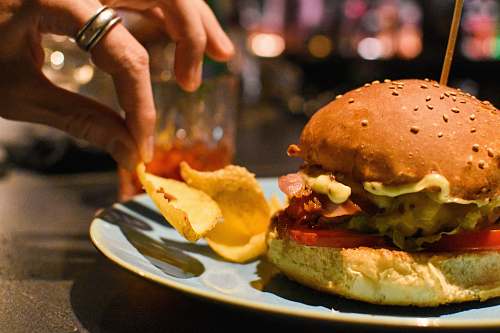 burger burger beside chips on plate human