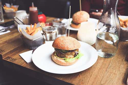 burger burger patty on plate served with fries and water bottle restaurant