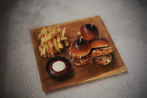 burger burgers and fries on brown wooden surface fries
