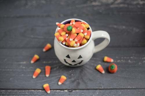 plant candies in mug and wooden surface carrot