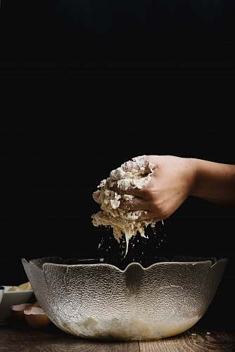 baking clear glass bowl on top of brown wooden table surface dough
