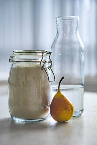 fruit clear glass jar near glass pitcher pear