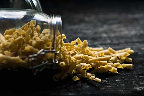 jar close up photo of yellow spiral pasta spilled jar pasta