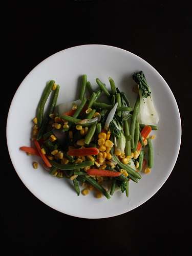 vegetable corns and sliced carrots on white plate bean