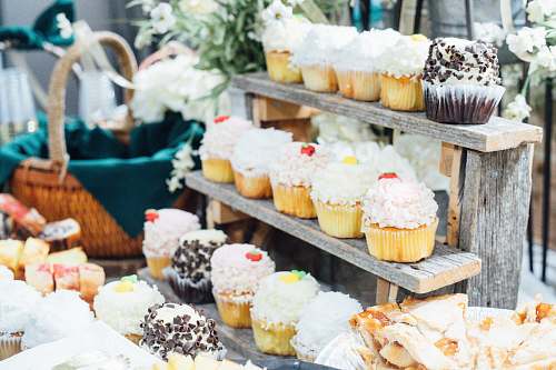creme cupcakes on wooden stand beside basket cream