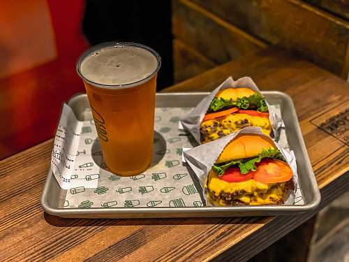 burger filled clear cup with two hamburgers on tray alcohol