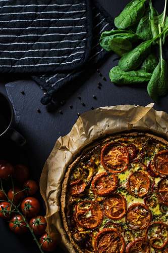 vegetable flat lay photography of two black pot holders beside tomatoes and pizza tomato