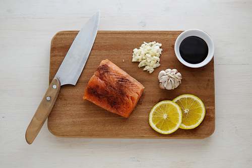 meal gray knife and orange flesh meat on wooden chopping board breakfast
