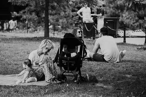 black-and-white grayscale photography of woman sitting on mat with baby meal