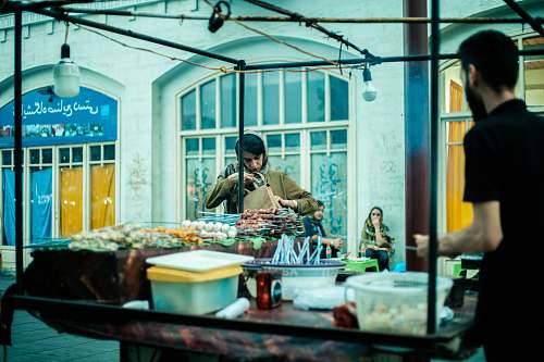 meal man in black polo shirt standing beside stand restaurant