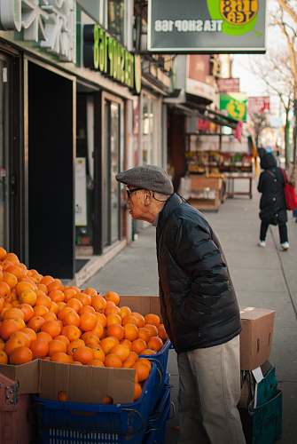 fruit man standing beside orange fruits display plant