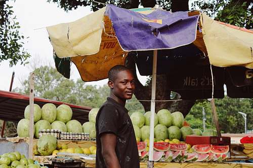 fruit man standing near watermelon fruit stand melon